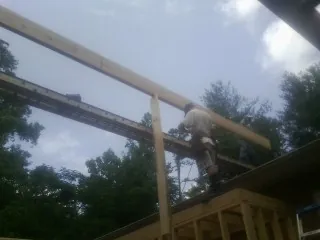 Carpenter setting a ridge beam over a new addition frame — Ice Dam Removal by Roofing Brothers in Starr