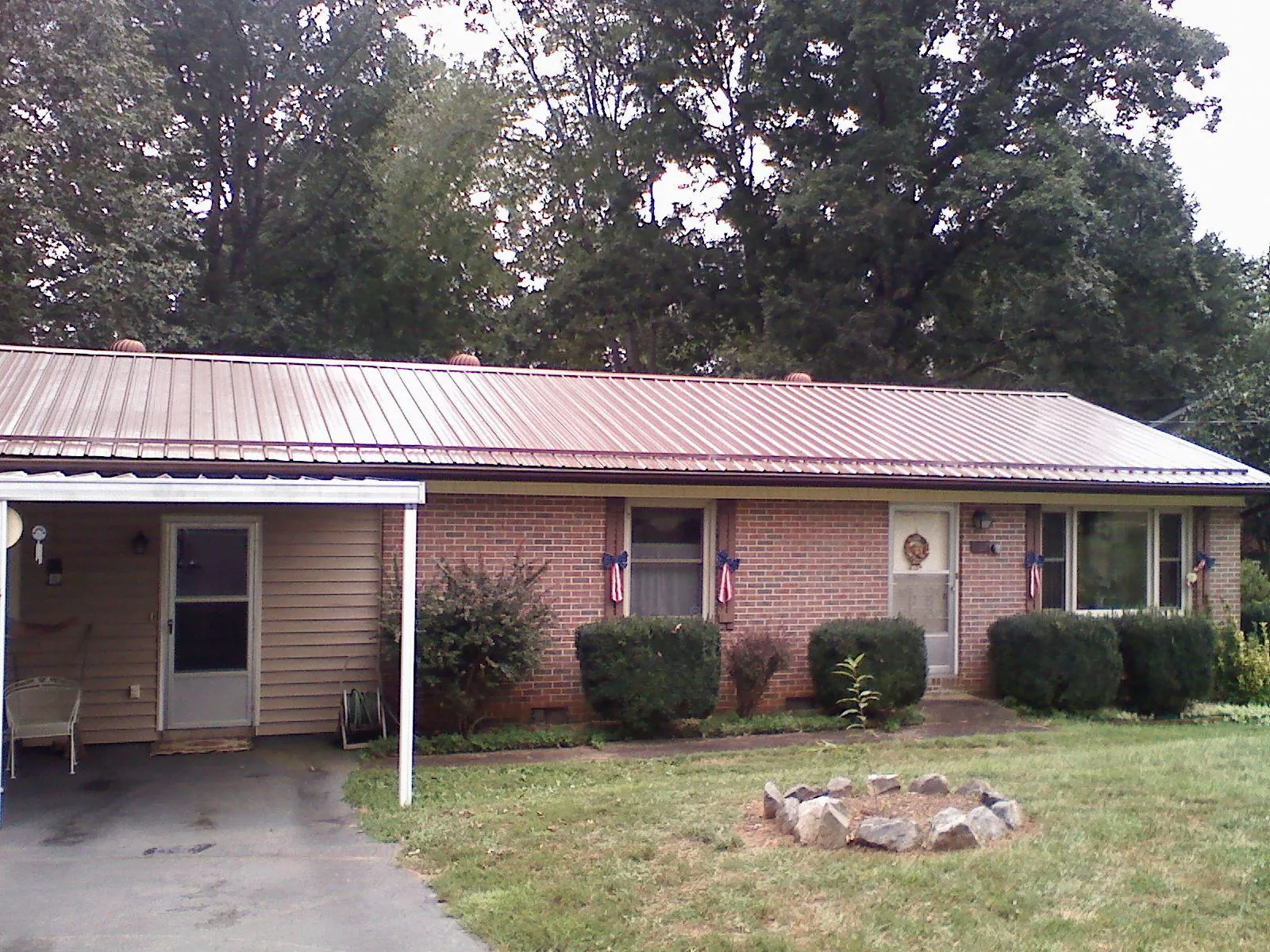 Bronze metal roof and carport on a brick ranch home — Roof Repair work by our crew in Starr